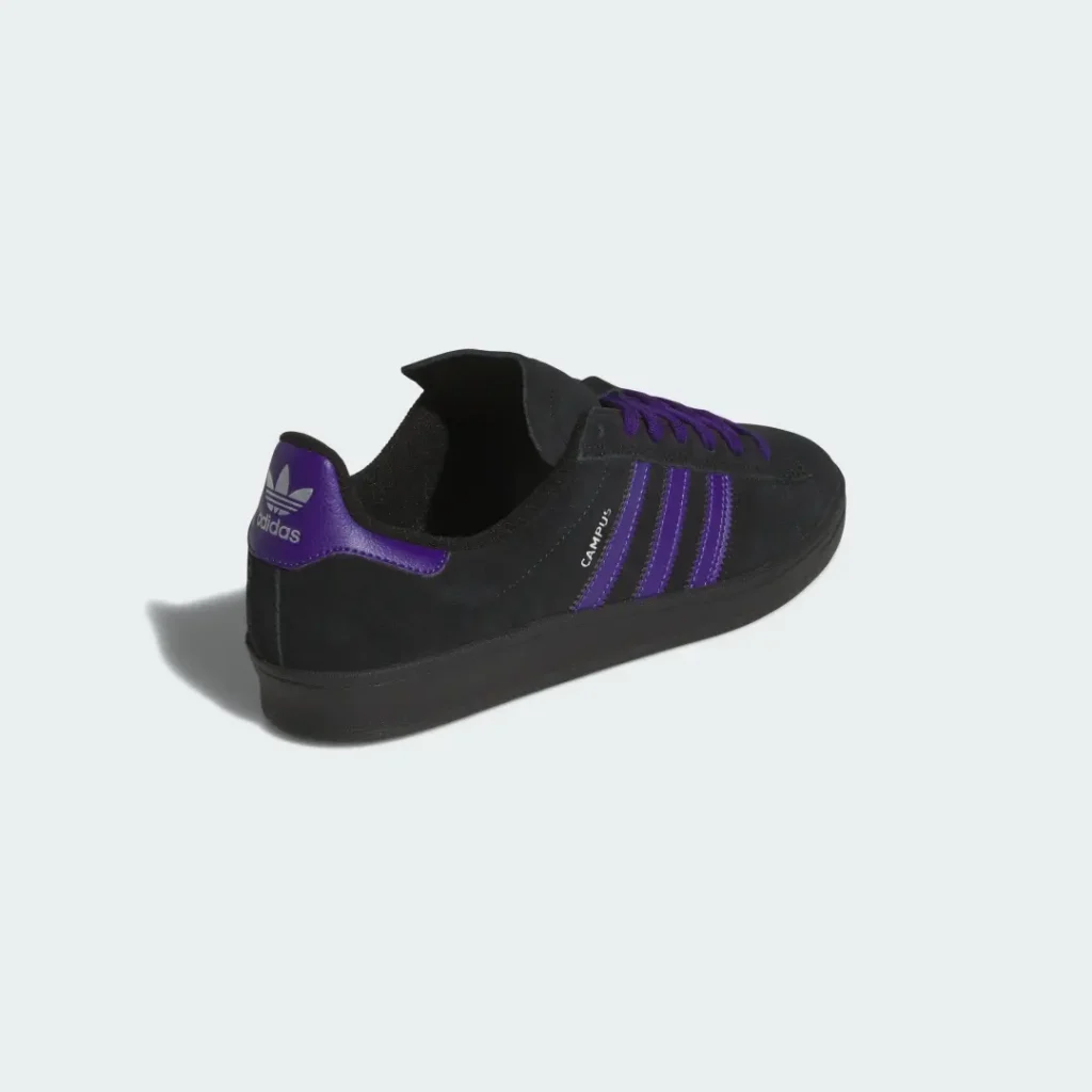 Black Campus low-top sneaker with purple laces, stripes and heel tab, isolated on a pale background
