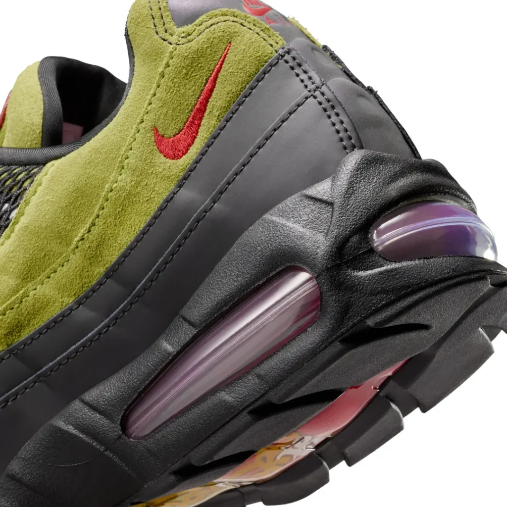 Close-up of the A Ma Maniére x Nike Air Max 95 heel showing the red embroidery Swoosh, black overlays, and purple-tinted view Air cushion
