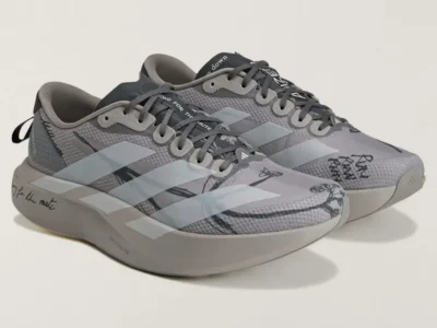 Pair of gray adidas Adizero running shoes with pale three-stripe branding, black sketch graphics, and handwritten detail