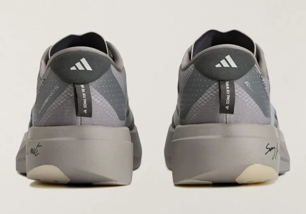 Rear view of the gray adidas shoes showing heel logos, pull tabs, paneled uppers, and oversized midsole