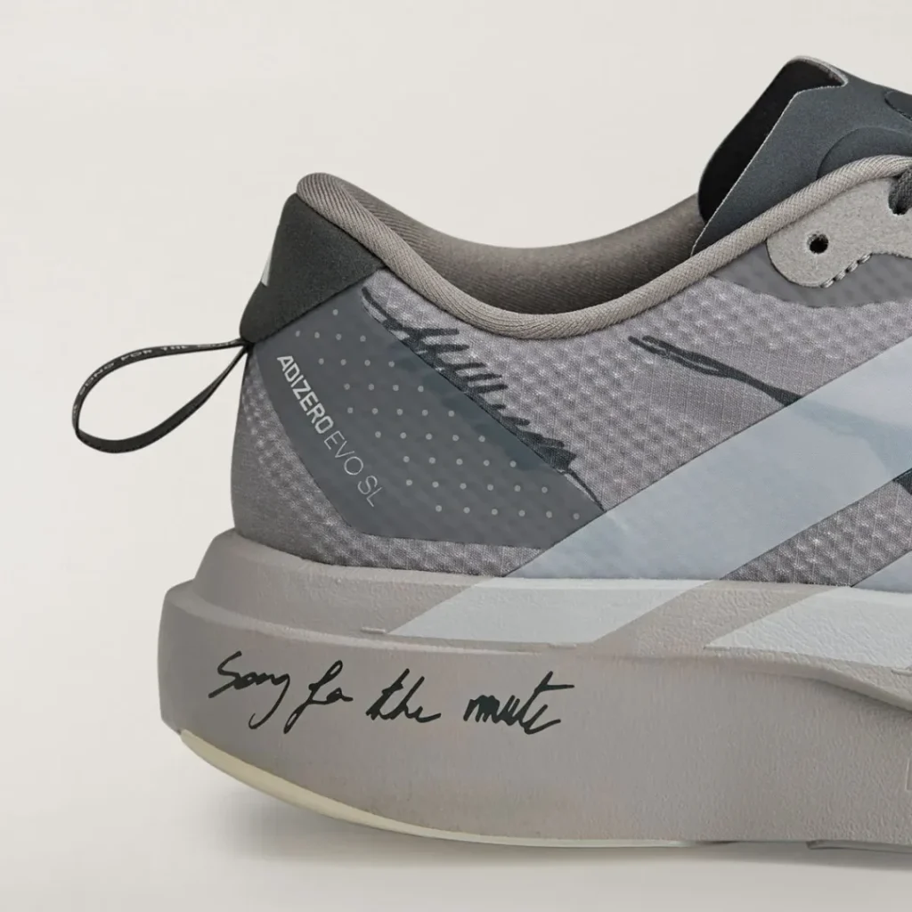 Close-up of the heel showing Adizero EVO SL branding, dotted detailing, pull tab, and “Song for the Mute” script