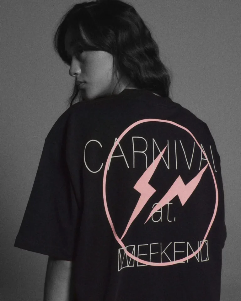 Woman from behind wear an oversize black Tee with a pink lightning-bolt logo, "CARNIVAL" and "WEEKEND" graphic text