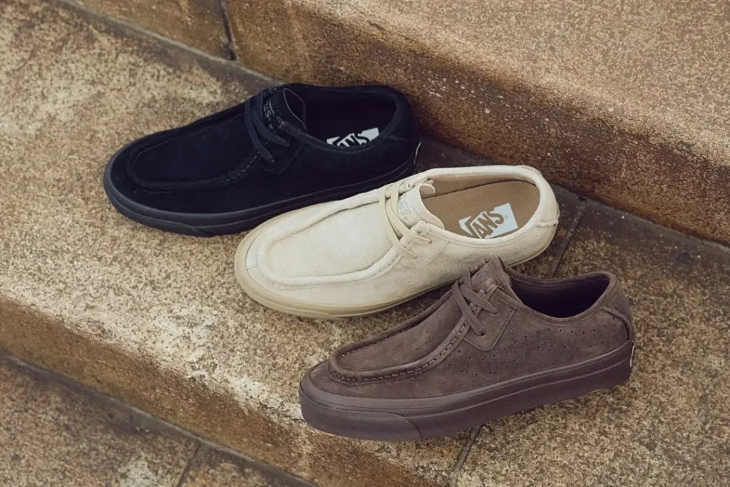 Vans Suede Moc Toe Shoe In Black, Cream, And Brown On Stone Step