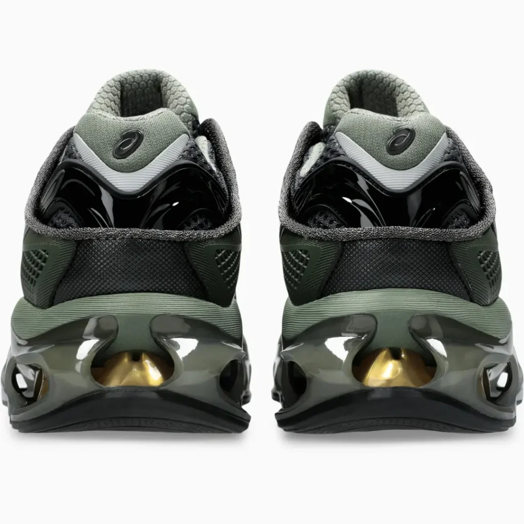 Rear view of the ASICS shoe featuring pad collars, glossy black heel clips, olive midsoles, and oversized heel cushioning with metallic gold internal accent