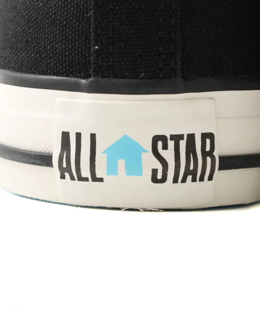 Close-up shows an All Star heel label with a blue house symbol replacing the star
