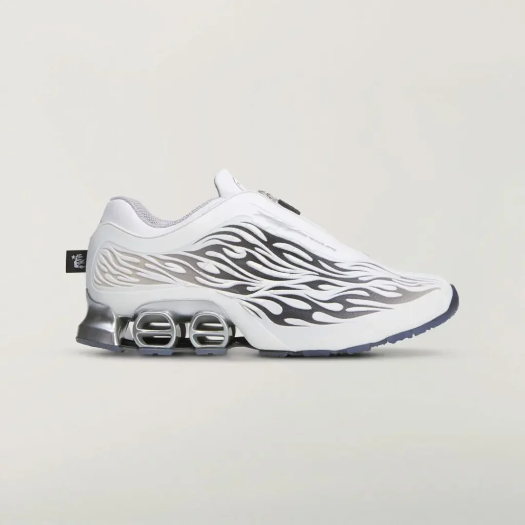 White adidas shoe in side profile with black and gray flame graphics, zip closure, and metallic silver sculpted heel cushion
