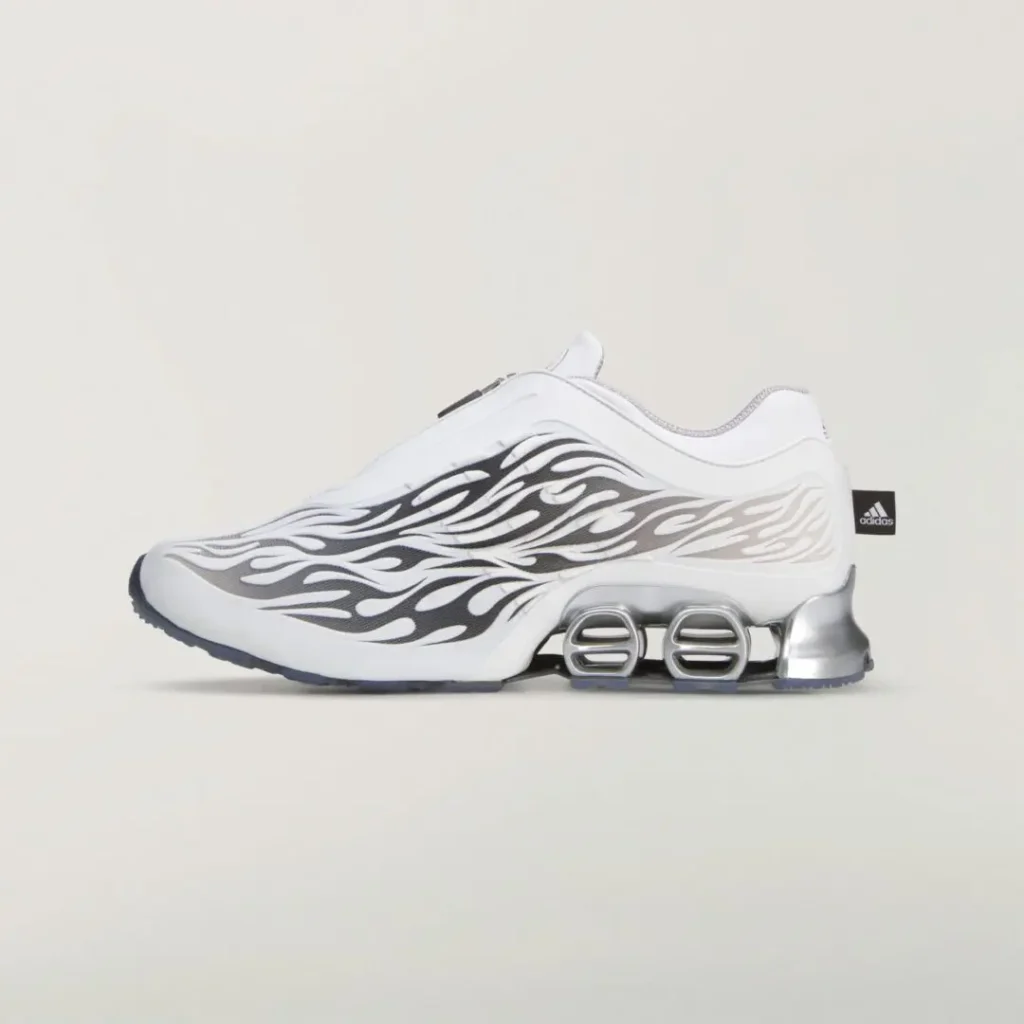 Opposite side profile showing the white upper, sweeping black and gray flame graphics, silver heel structure, and translucent outsole
