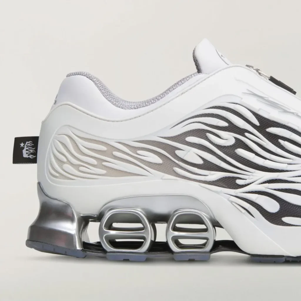 Close-up of the heel and midsole show layered flame graphics, metallic silver cushioning pods, and a small black graphic pull tab