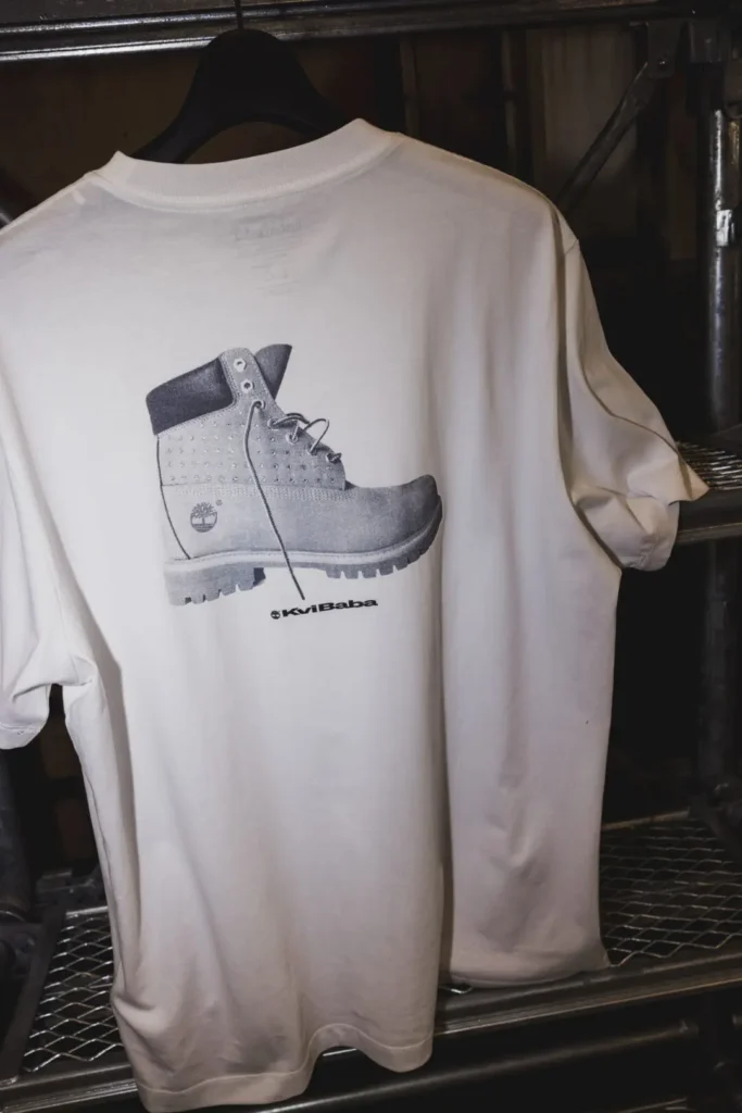 Back of a white Timberland x Kvi Baba Tee feature a grayscale stud boot graphic