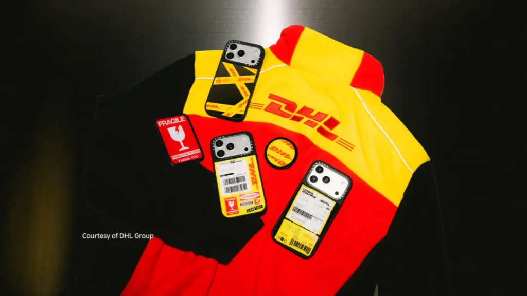 DHL-branded red and yellow jacket with three shipping-label phone cases and fragile-package patches on a dark background