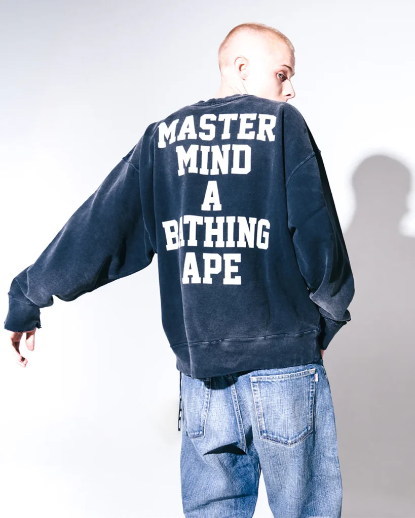 Rear view of the wash black sweatshirt featuring oversized white “MASTER MIND A BITHING APE” letter