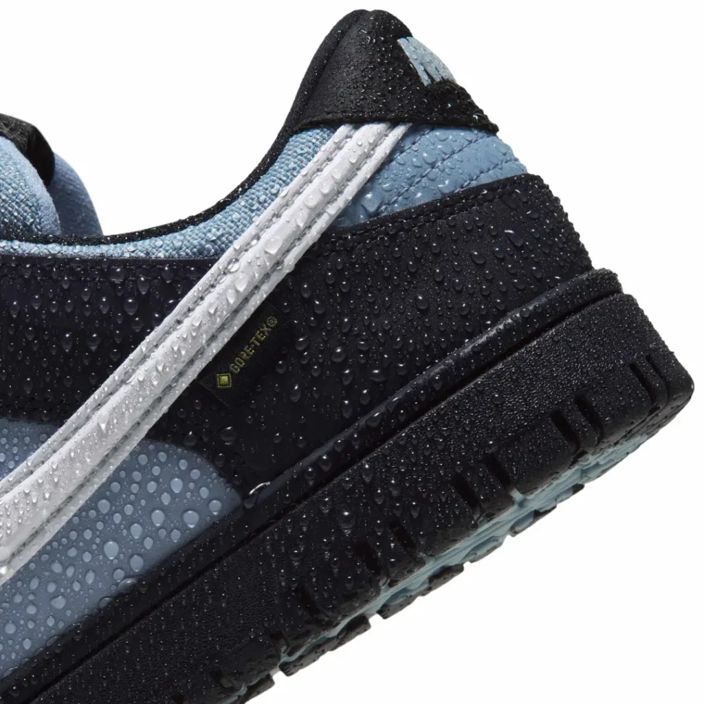 Close-up of a black and blue Nike Dunk Low sneaker covered in water droplets, with GORE-TEX label visible