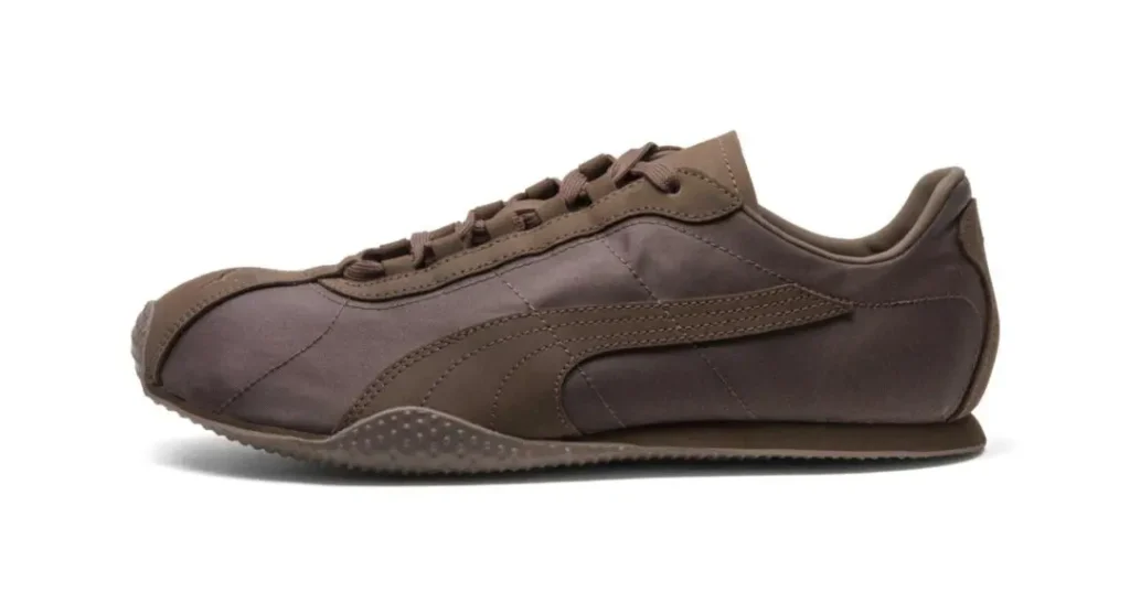 Brown low-top sneaker with tonal laces, stitched side stripes, and textured rubber sole on a white background