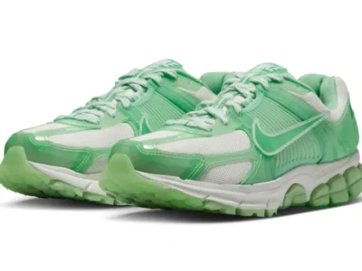 Mint green and white Nike Vomero 5 shoe with glossy translucent overlays, white mesh panels, matching green laces, and segmented Cushlon sole