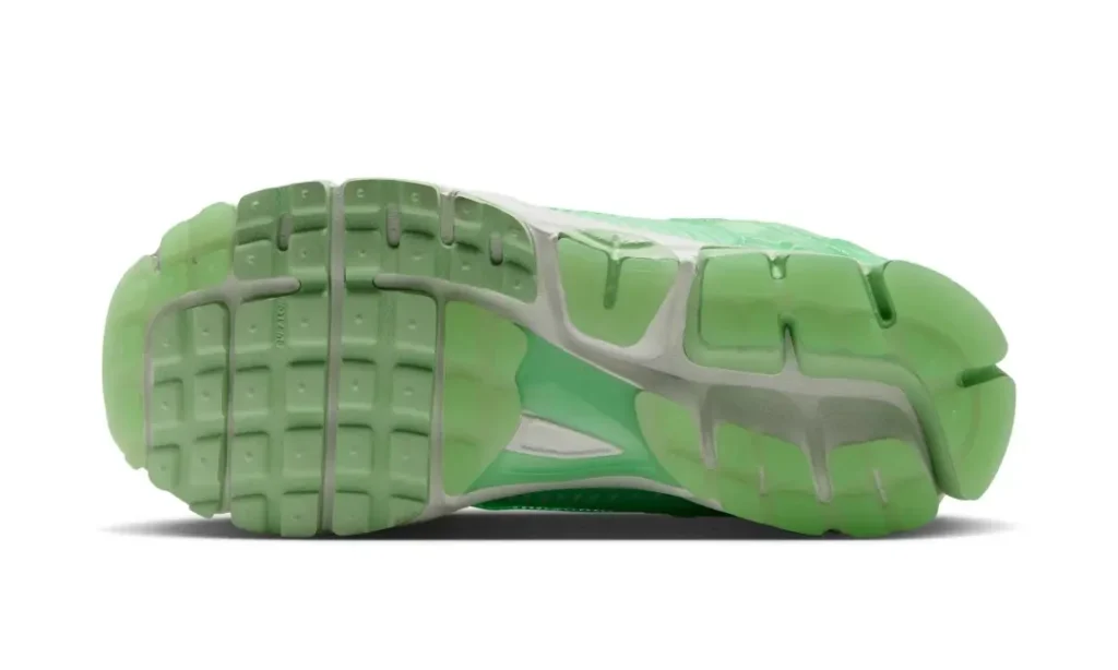 Green rubber outsole with segment traction pods and exposed white midfoot shank, shown from the bottom