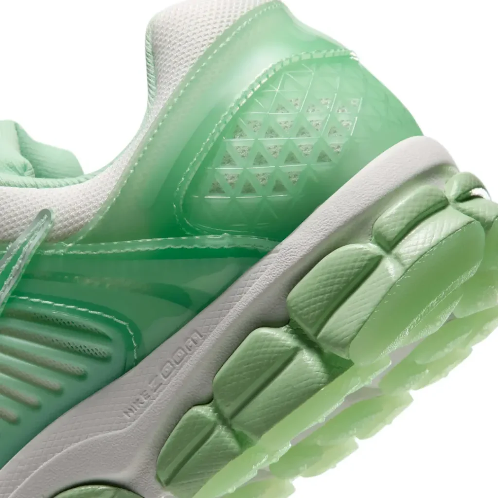 Close-up of the heel highlight the translucent triangular-pattern heel counter, Cushlon midsole brand, and oversized green outsole pod