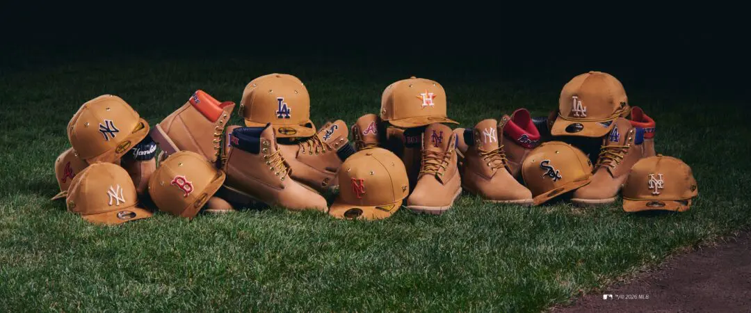 Timberland x New Era x MLB tan boots and matching fitted team caps arranged across a baseball field.