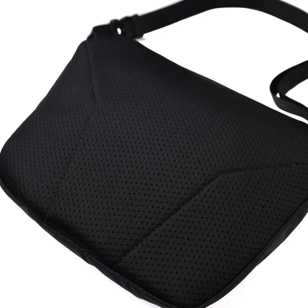 Detailed view of the padded black mesh back panel showcasing perforated cushioning, ergonomic quilting, and soft-contact construction for enhanced comfort