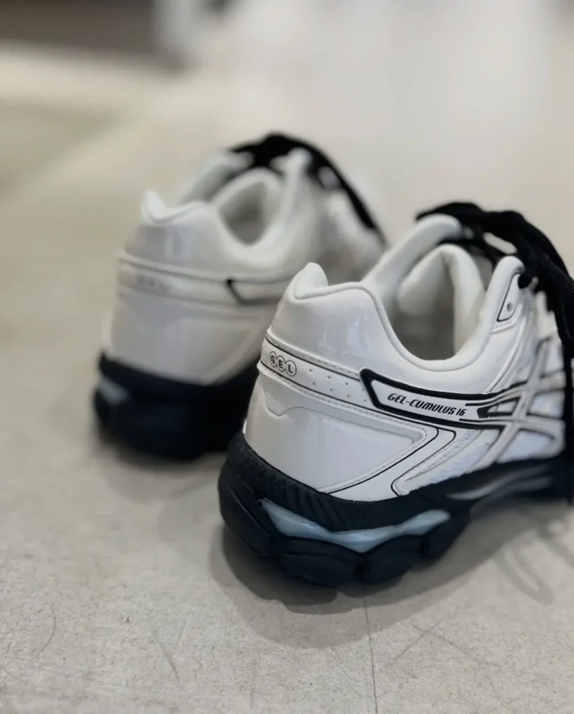 Rear three-quarter view of the ASICS GEL-CUMULUS 16 showcase the padded heel, GEL branding, layered heel counter, and black segmented outsole