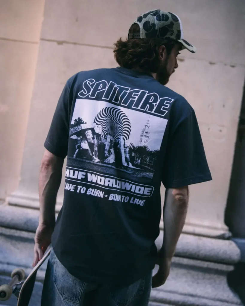 Rear view of a black HUF x Spitfire graphic Tee featuring a large Spitfire-inspired collage print