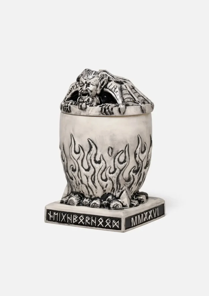 Three-quarter angle view of the Neighborhood incense chamber with the lid on. Both the runic plaque on the left (reading "MIXNBORNOOD") and the "MMXXVI" plaque on the right side of the base are view, show how the text wrap around the corner