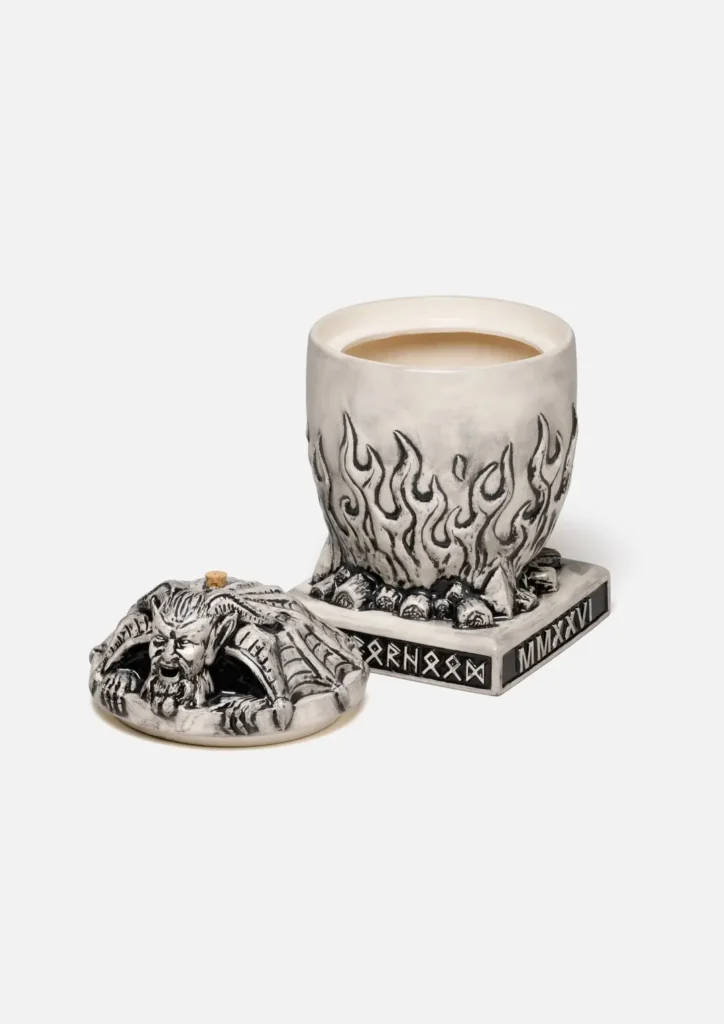 Disassembled view of the Neighborhood incense chamber. The lid with the demon gargoyle sits to the left, reveal its hollow interior. The main body is shown with the lid removed, displaying the white ceramic interior meant for holding the incense. The runic and "MMXXVI" plaque are clearly view on the base