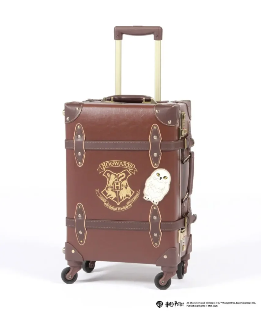 Brown vintage-style rolling suitcase feature the Hogwarts crest and Hedwig graphic