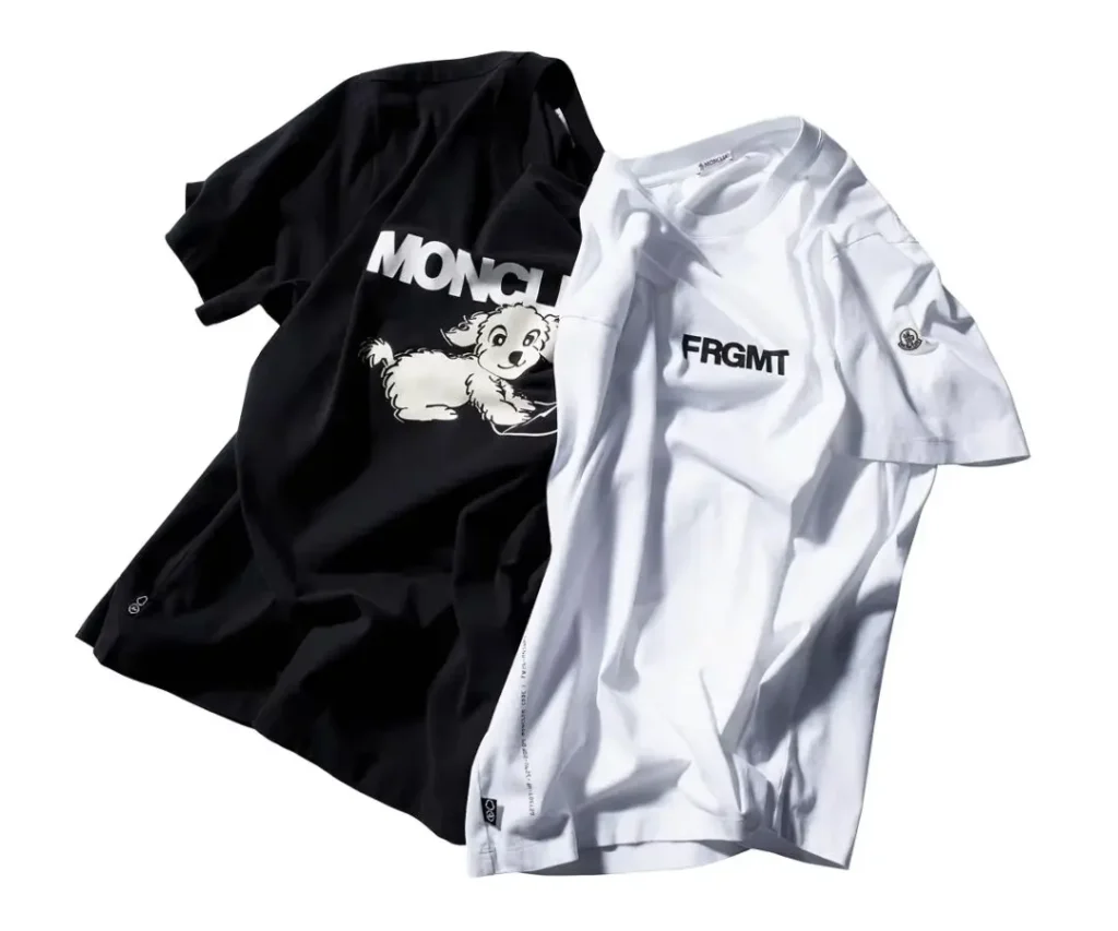 Two folded tee against a white background. The black shirt features a graphic of a cartoon dog with the text "MONCLER." The white shirt feature the text "FRGMT" in bold black letter, along with the Fragment lightning bolt logo