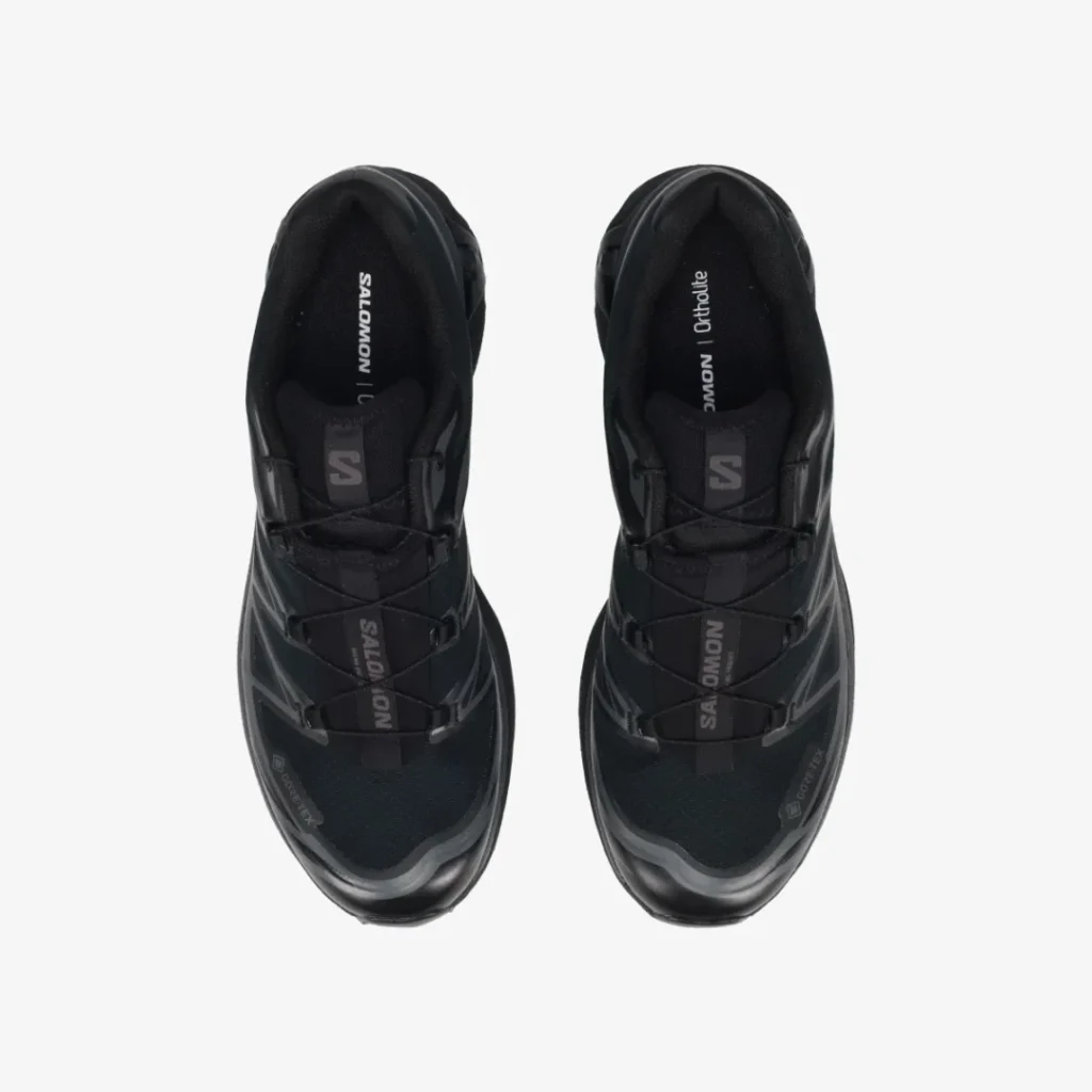 Top-down view of a pair of black Salomon lace-up trail shoes on a white background