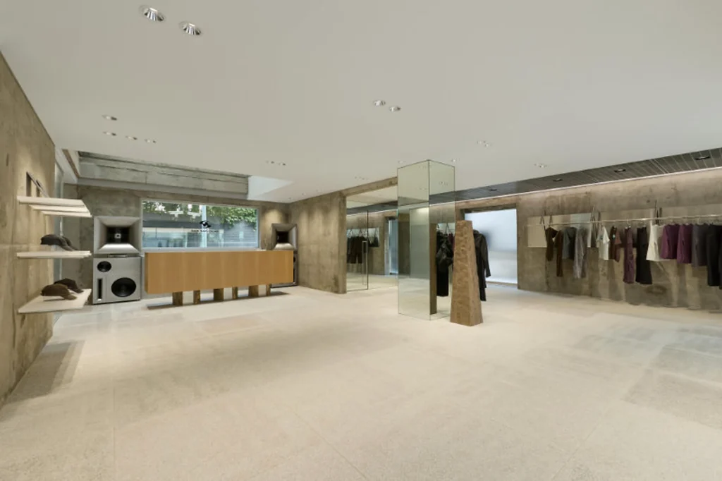 Wide Concrete Retail Interior With Clothing Display And Mirror Column