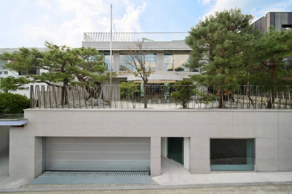 Modern Concrete Building Exterior Surrounded By Pine Trees And Landscape