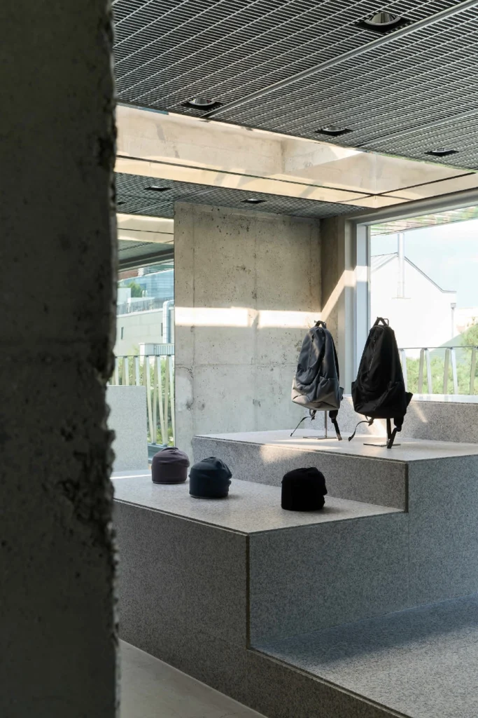 Backpack And Caps Display On Tiered Stone Platform By Large Window
