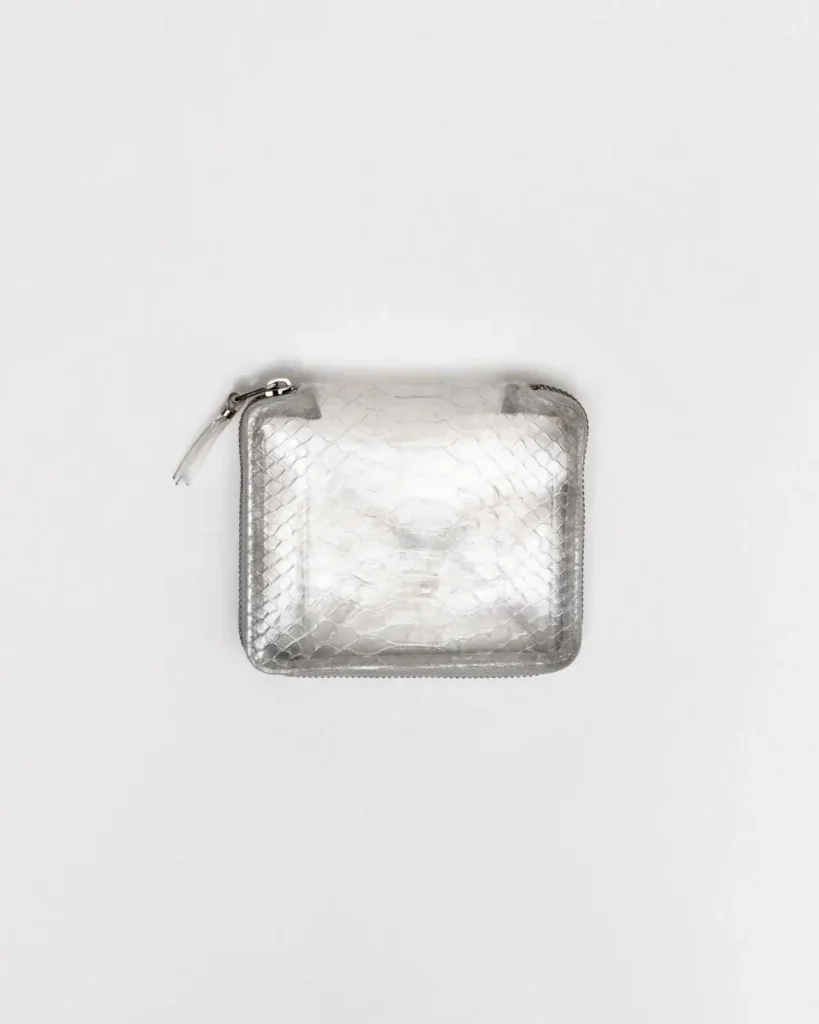 Metallic silver python leather zip-around wallet with a glossy snakeskin texture, rounded corners, and matching leather zipper pull