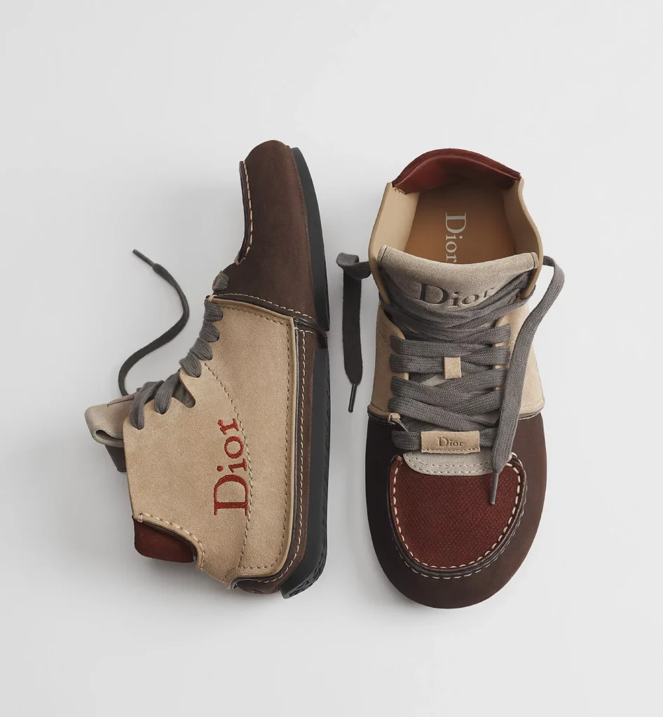 Pair of Dior high-top shoes in beige, brown, and burgundy suede with gray laces and visible logo detail