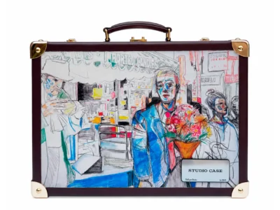 Vintage burgundy leather studio case with gold hardware, featuring a hand-drawn fashion illustration of figures, flowers, and an urban interior in vivid blue, red, orange, and green accent
