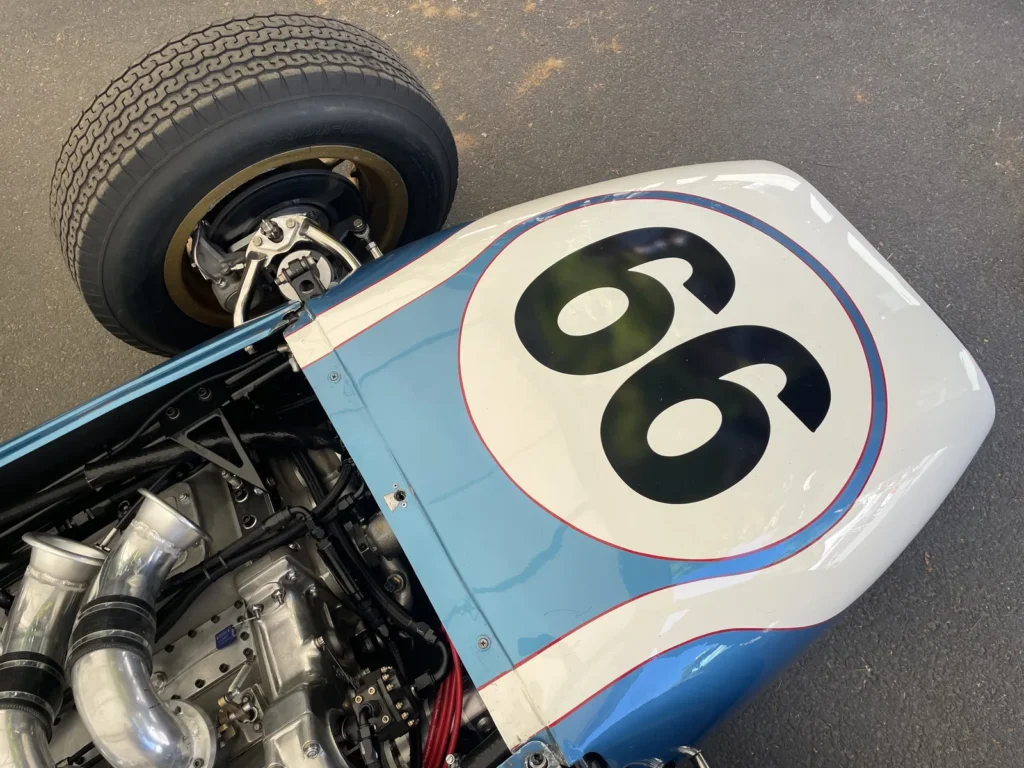 Vintage Race Car Number 66 With Exposed Engine And Blue White Bodywork