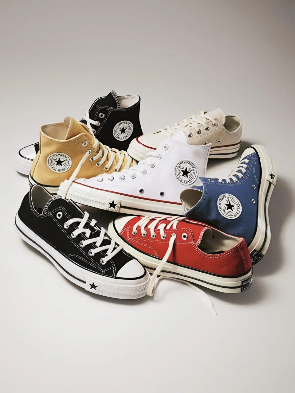 Classic Converse Chuck Taylor All Star sneakers in multiple high-top and low-top colorways arranged together on a clean studio background.