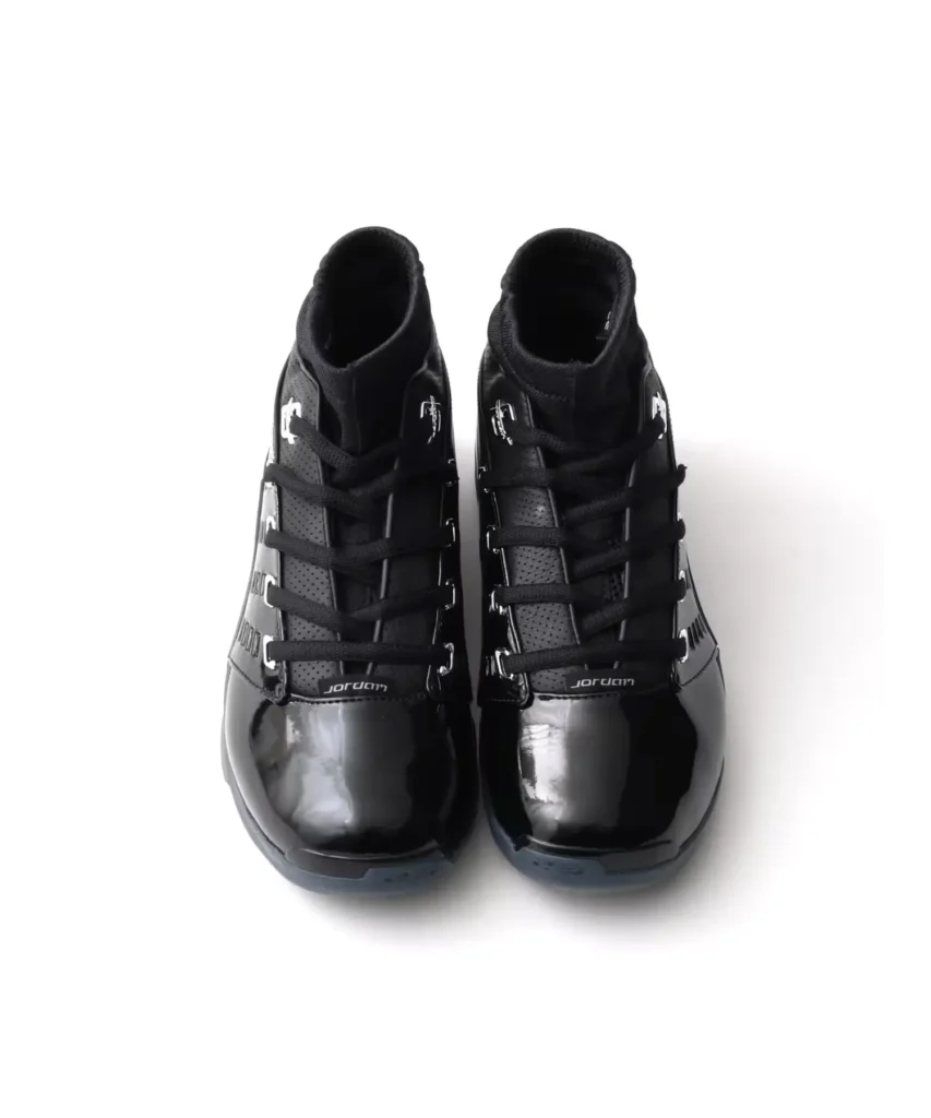 Top-down view of a pair of black Jordan high-tops with black laces and glossy patent leather toe box