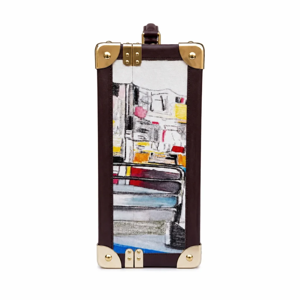 Open brown trunk displaying a colorful abstract painting, with brass corner plates and latches against a white background