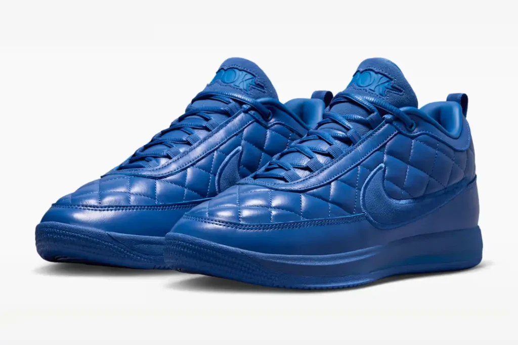 Three-quarter view of a pair of blue Nike shoe with padded quilt leather, suede Swooshes and tonal blue sole