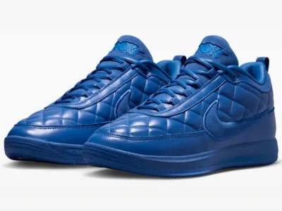 Three-quarter view of a pair of blue Nike shoe with padded quilt leather, suede Swooshes and tonal blue sole