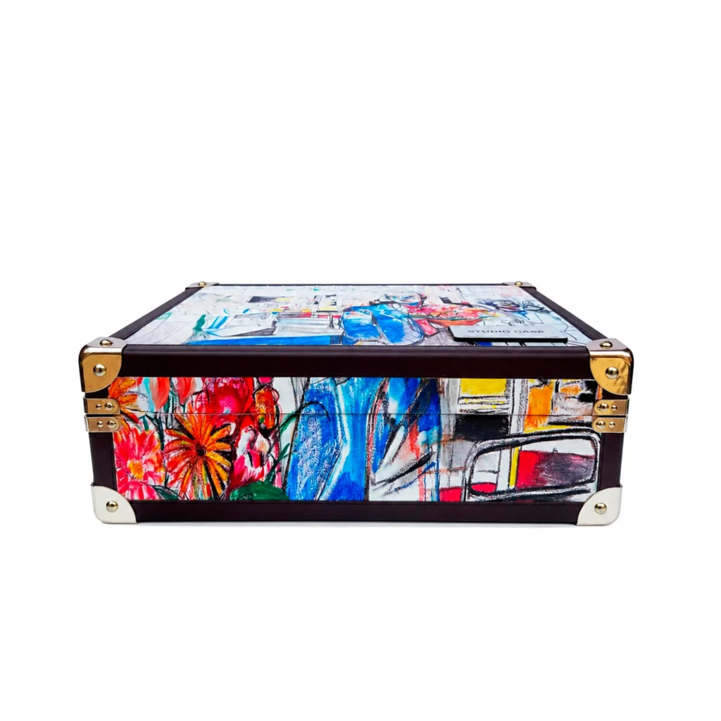 Low-Angle View Of Burgundy Studio Case Featuring Gold Corner Hardware And Vibrant Hand-Drawn Floral And Fashion Artwork