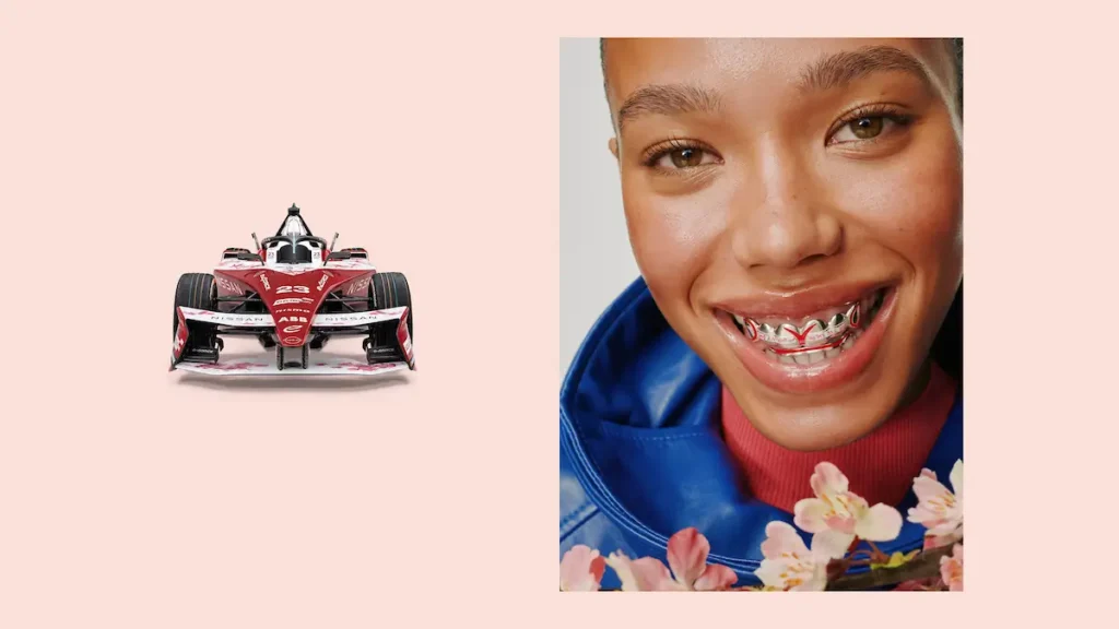 Red Formula E Race Car Beside A Smiling Model Wearing A Matching Grill And Blue Jacket