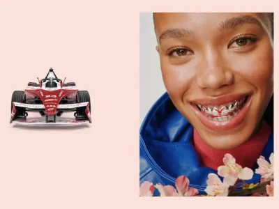Red Formula E Race Car Beside A Smiling Model Wearing A Matching Grill And Blue Jacket