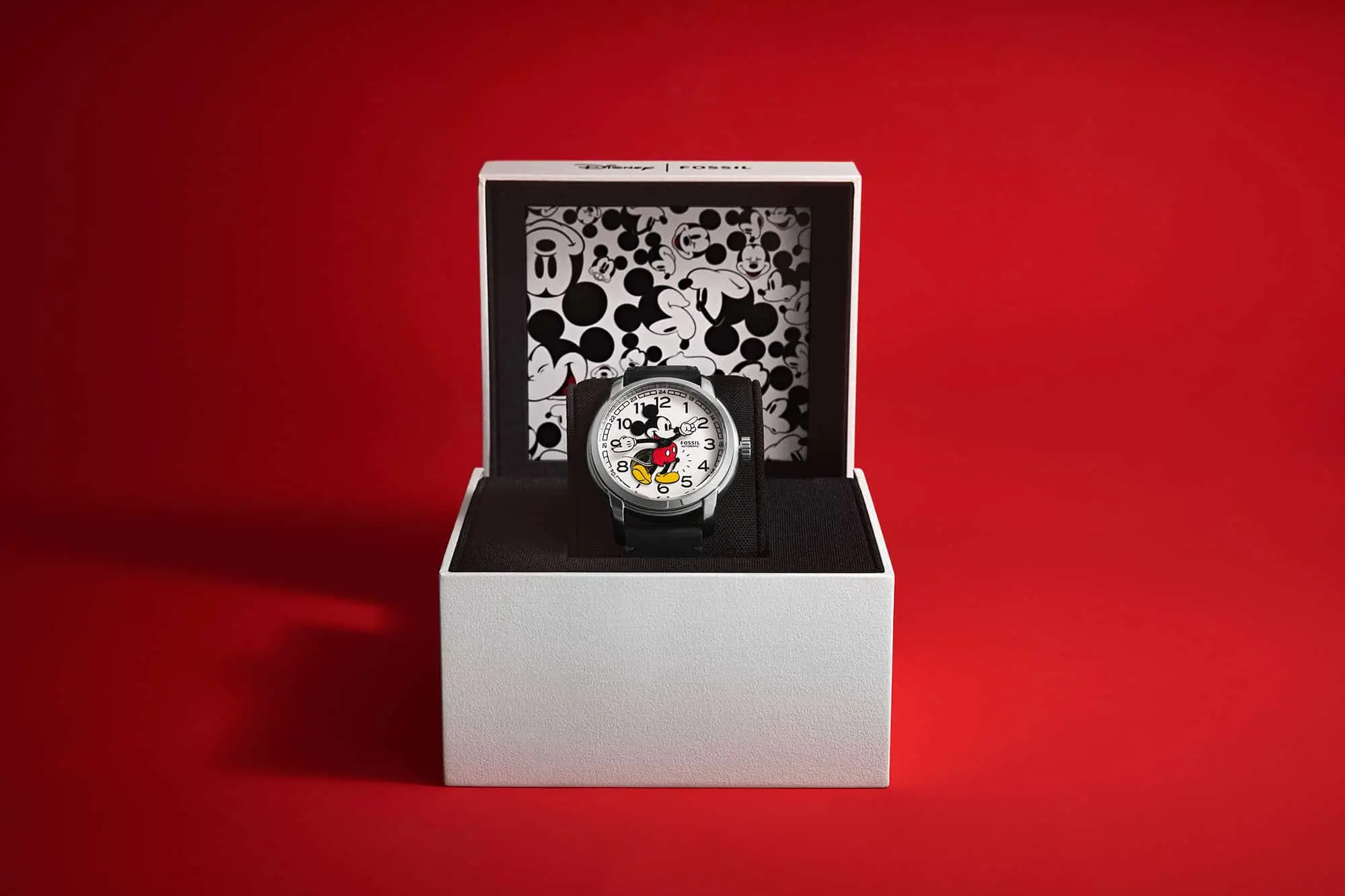 Fossil Mickey Mouse Watch Sits Inside An Open Collector Box Against A Red Background.