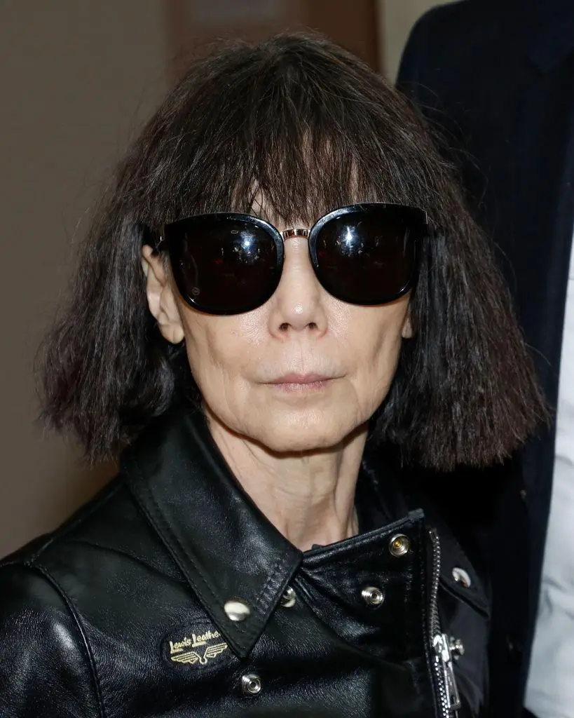 Portrait of a woman with a dark bob, oversized black sunglasses, and a black leather jacket.