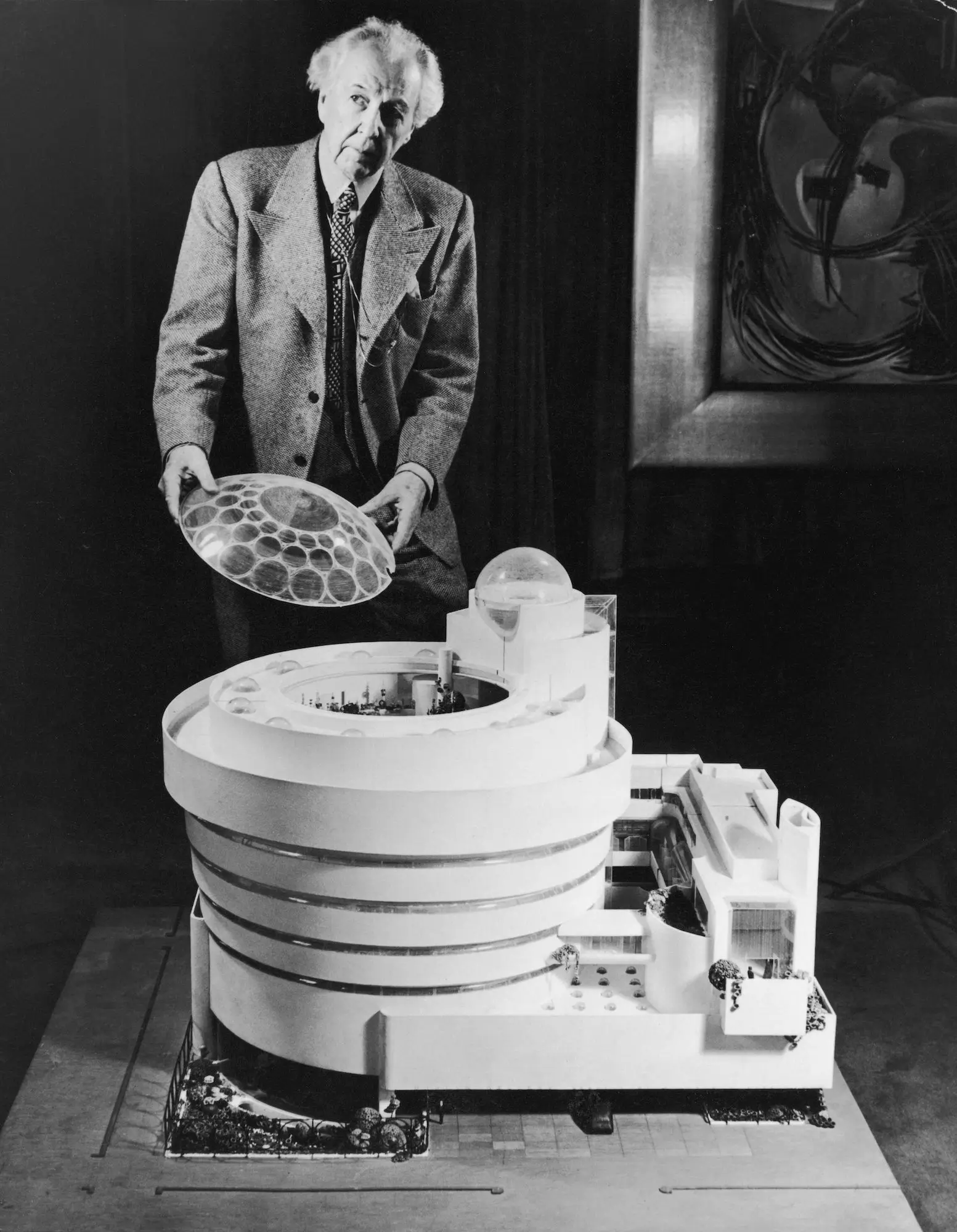 Frank Lloyd Wright Stands Behind An Architectural Model Of The Solomon R. Guggenheim Museum.