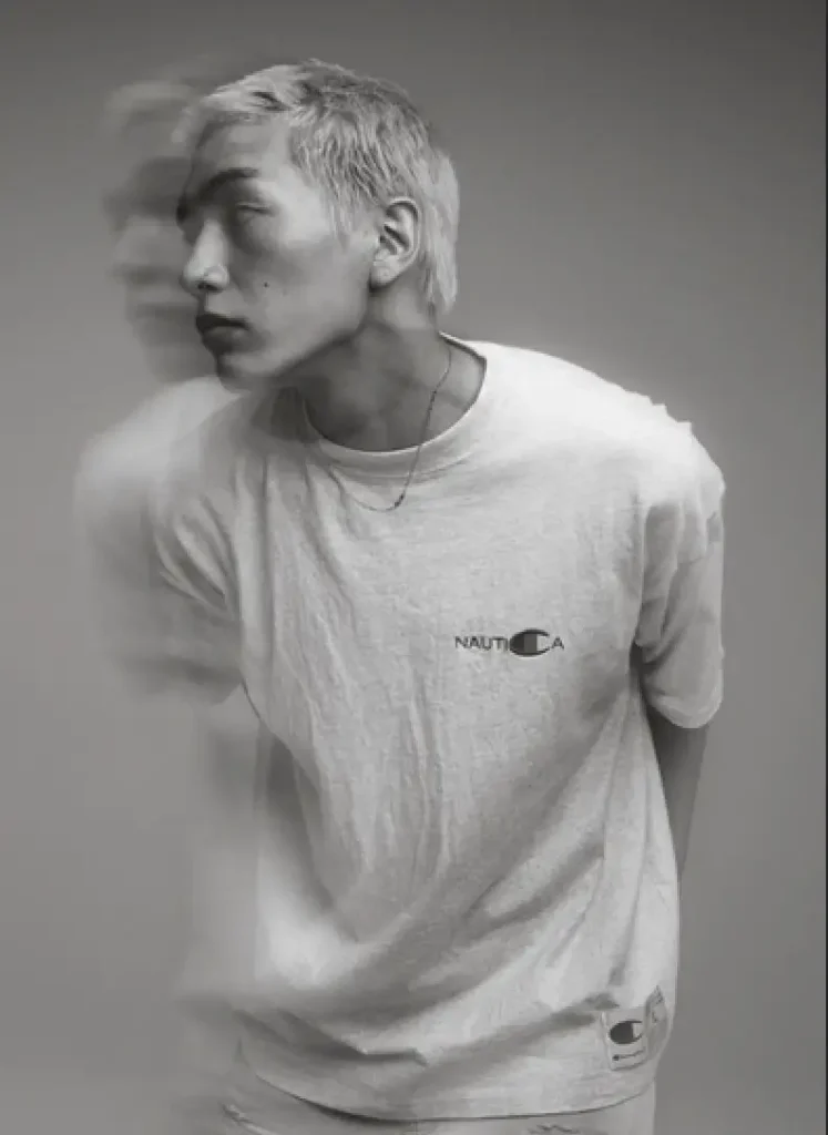 Model Wear A Light Gray Champion X Nautica Tee In A Black-And-White Portrait With Layer Motion Blur