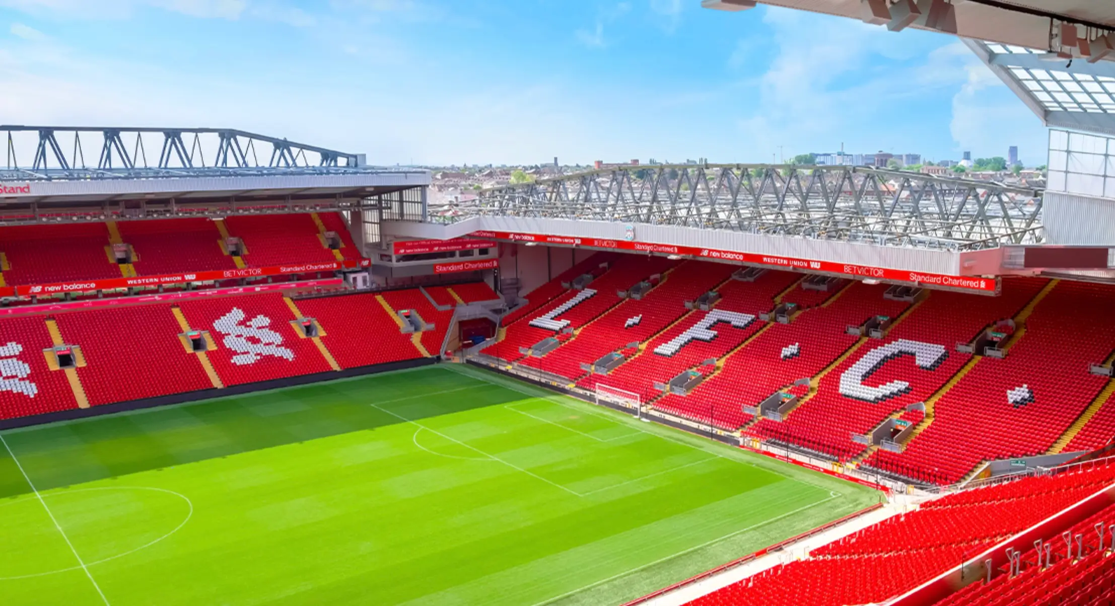 Anfield Stadium Interior With Red Liverpool FC Seating And Green Football Pitch