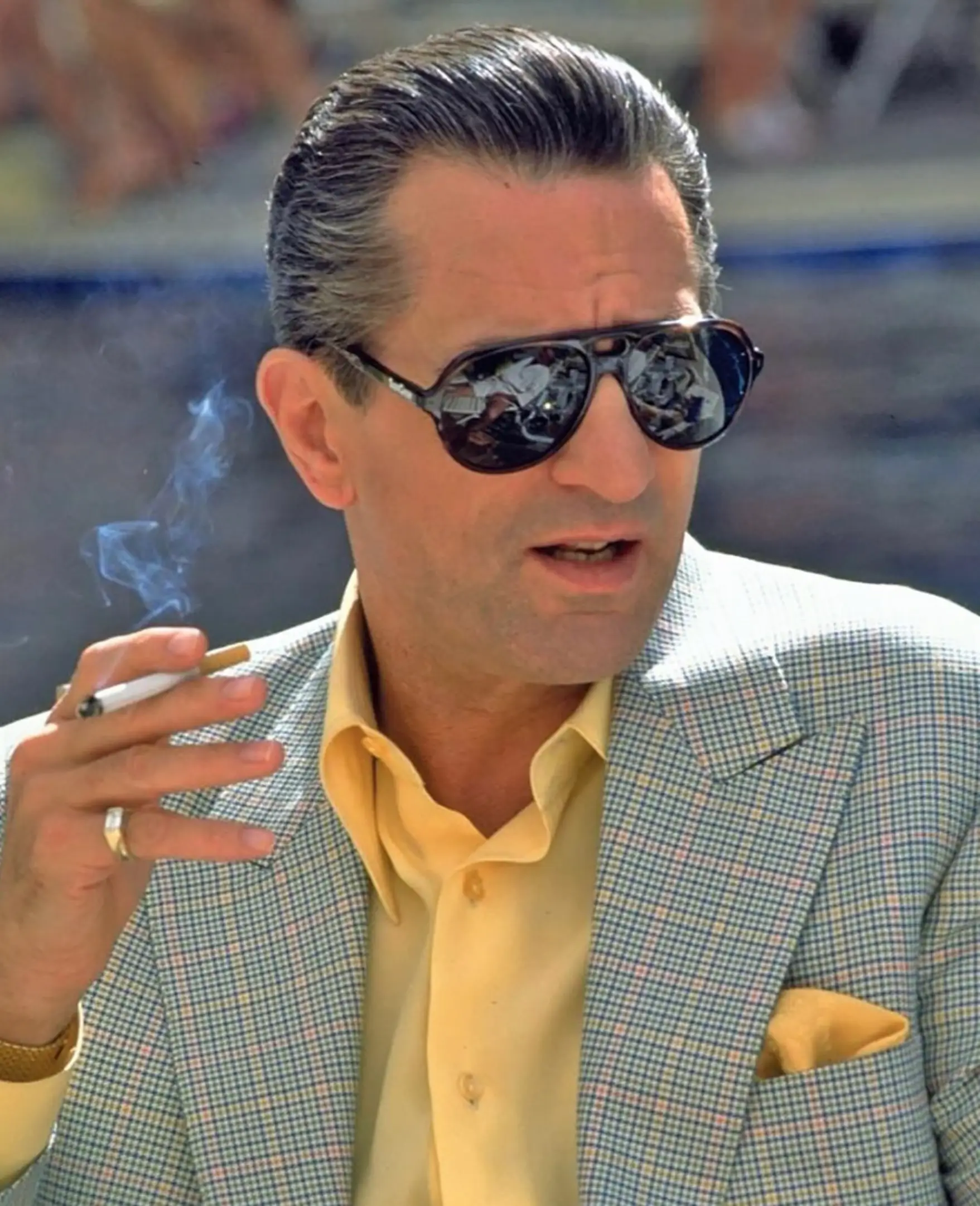 Robert De Niro wears sunglasses and holds a cigarette in Casino.